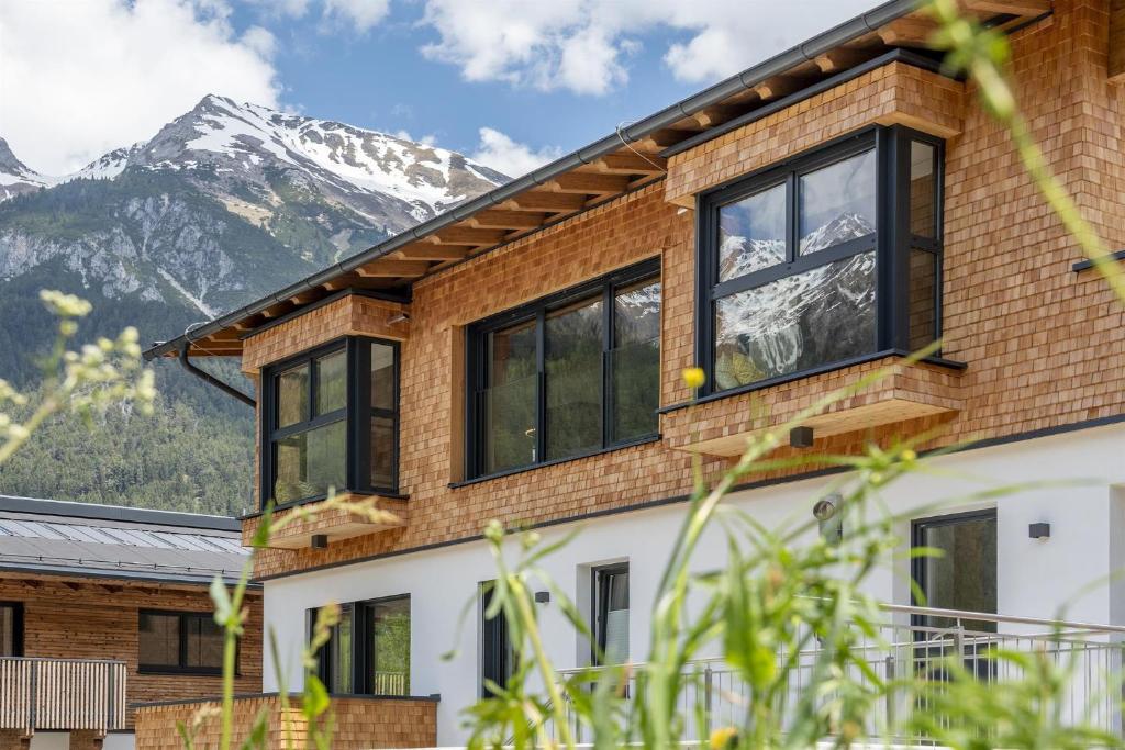 佩特诺伊阿尔贝格Chalet Vega - Arlberg Holiday Home的房屋设有窗户,后面是群山