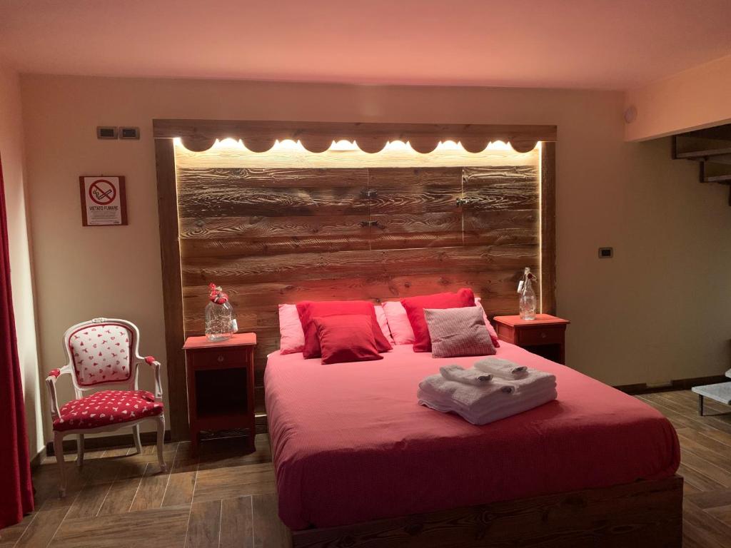 奥斯塔Ca di Nadia的一间卧室配有一张带红色床单的大床和椅子