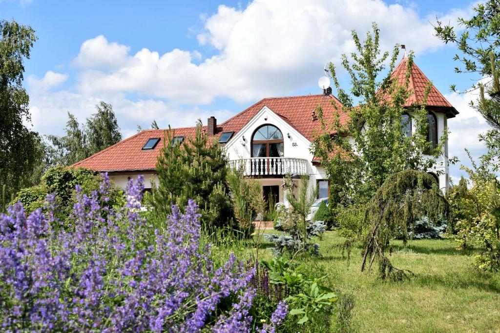 Goławin"Route 62" Airport Modlin的一座带花园和紫色鲜花的房子