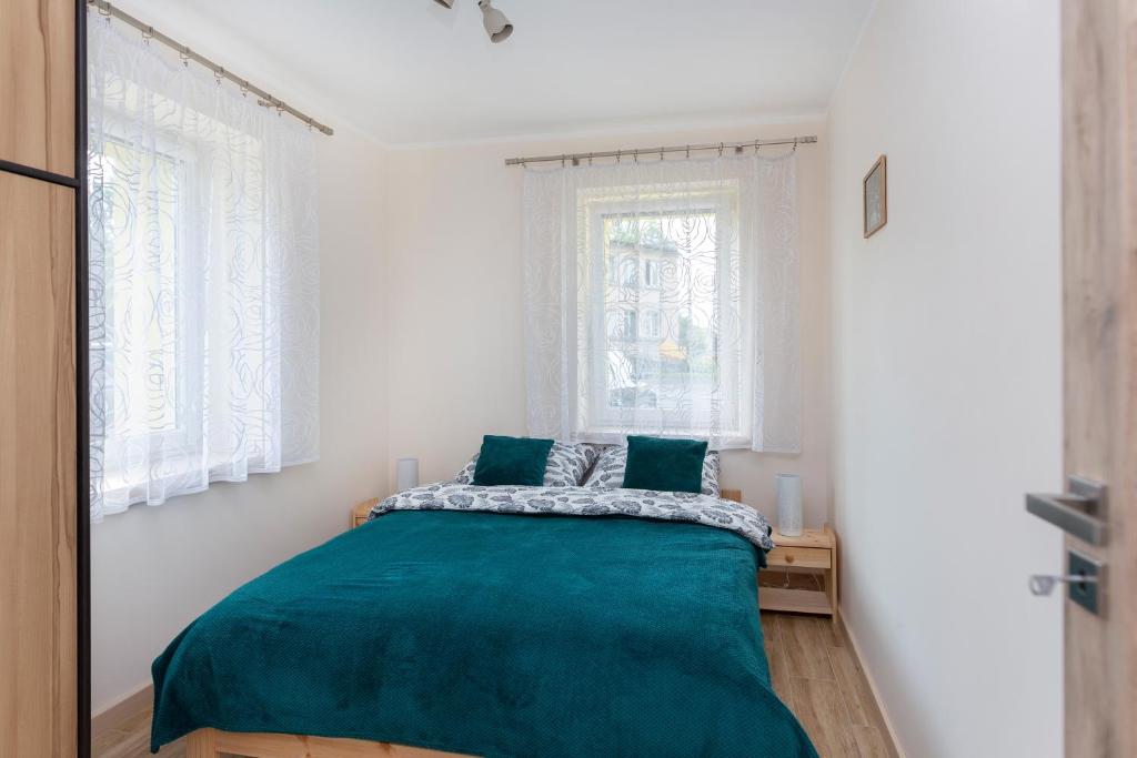 库多瓦-兹德鲁伊przystanek Kudowa的一间卧室配有一张带绿毯的床