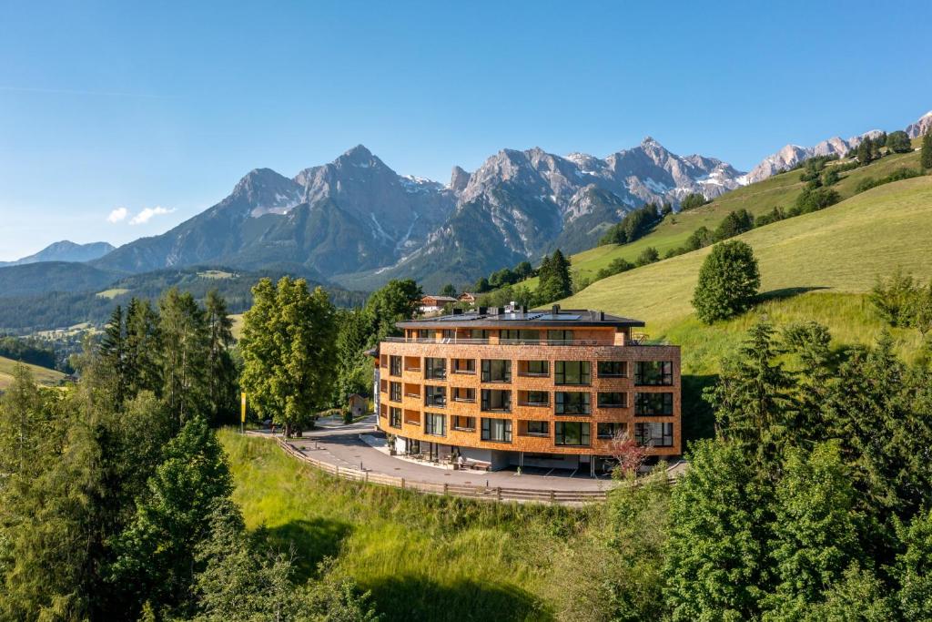 玛丽亚阿尔姆Apartmenthotel Sonnenhof的山丘上的建筑,背景是山脉