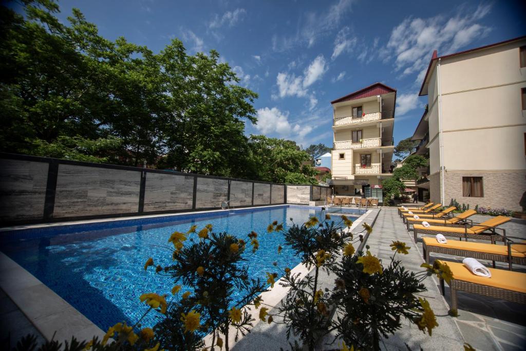 科布列季Hotel Chveni Ezo的一座带躺椅的游泳池位于大楼旁