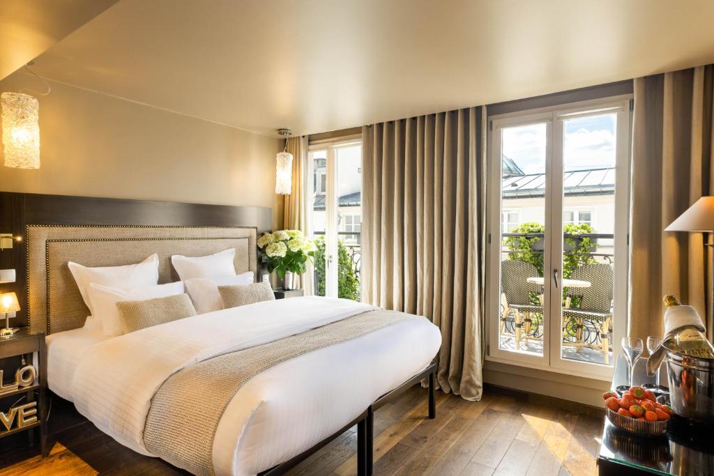 巴黎蒙马特B酒店的一间带大床的卧室和一个阳台