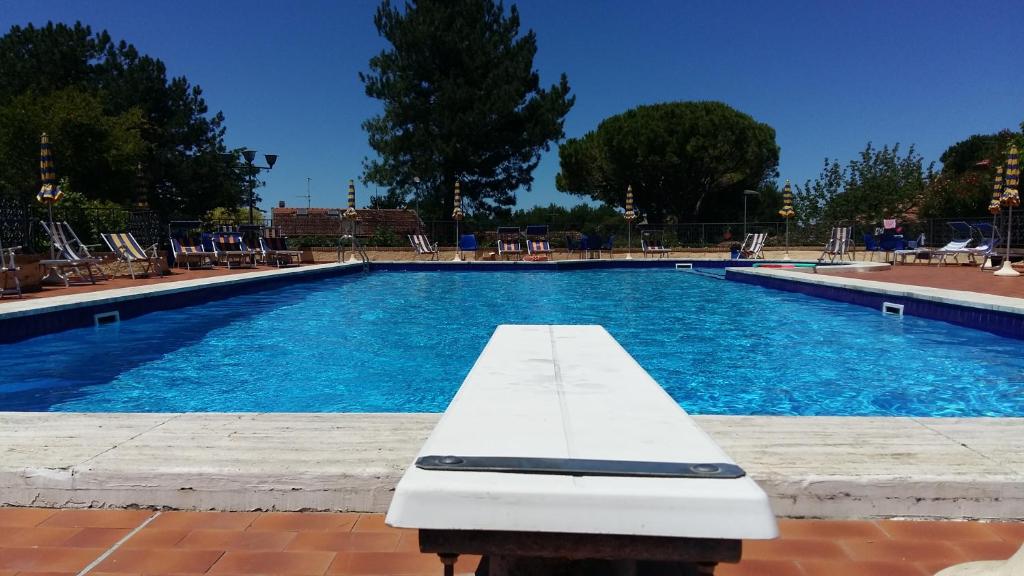加比切马莱Residence Vigna del Mare的前面设有白色长凳的游泳池