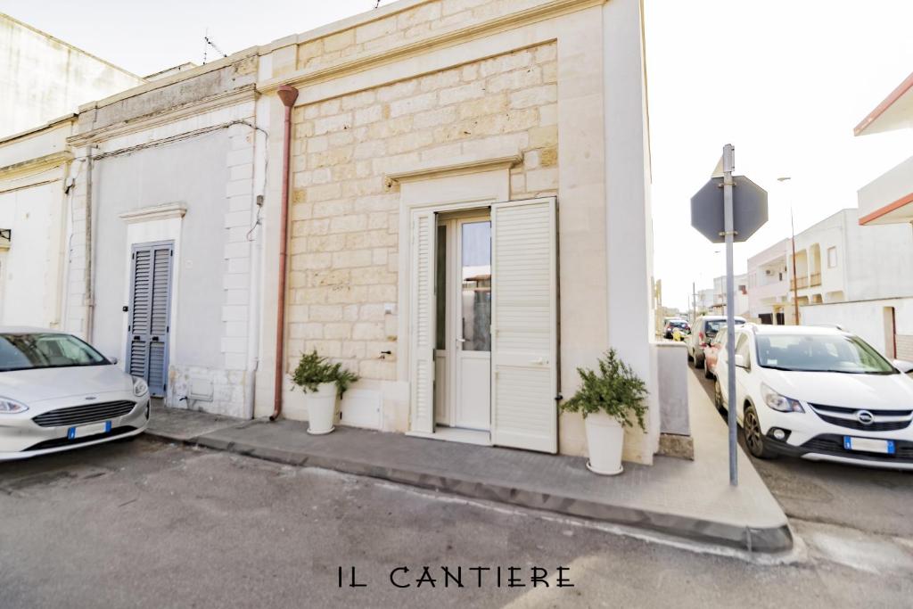 梅伦杜尼奥Il Cantiere - Casa Di Una Volta.的两辆汽车停在大楼旁边的停车场