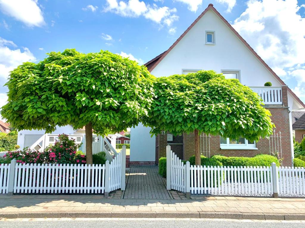 索尔陶Ferienwohnung HeideZeit Soltau - Neu mit Spielturm的一座大树屋前的白色围栏