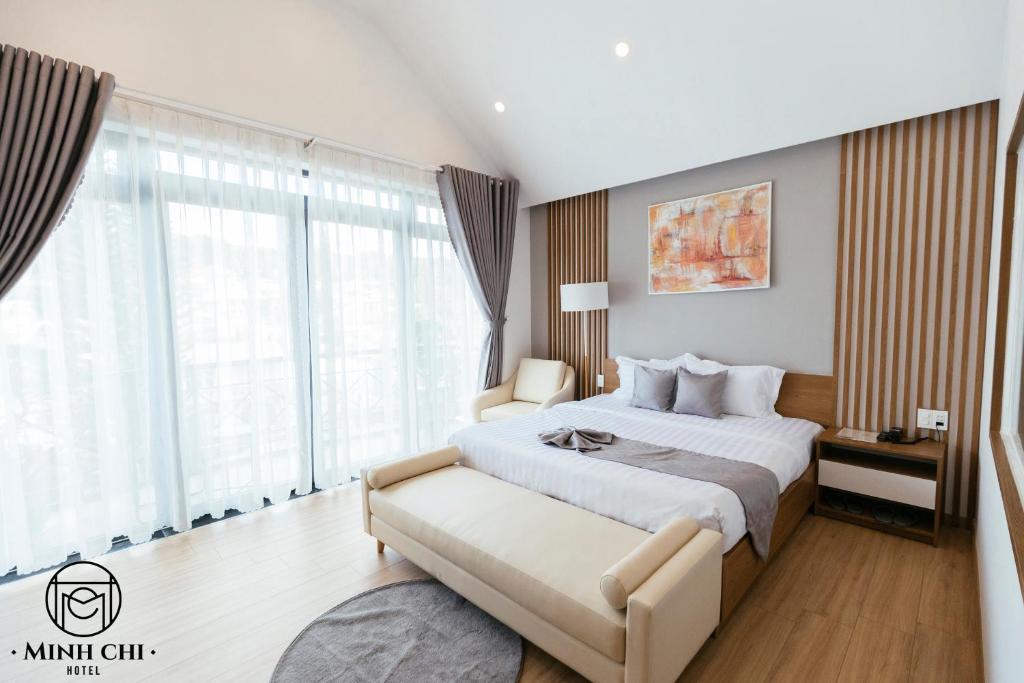 大叻Minh Chi Hotel的一间卧室设有一张大床和一个大窗户