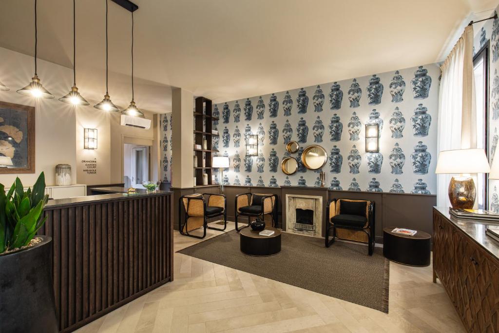 博洛尼亚波尔塔圣马莫洛酒店的客厅设有壁炉,并装饰有蓝色和白色的壁纸