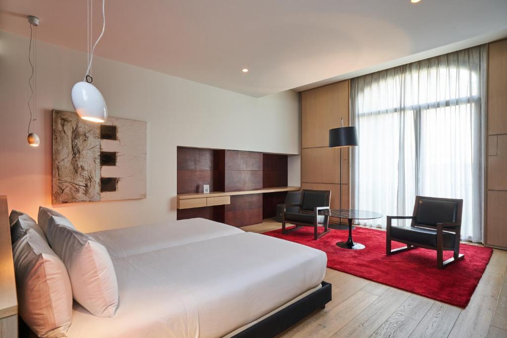 维拉弗兰卡宾纳戴斯奎尔居美世酒店的卧室配有一张床和一张桌子及椅子