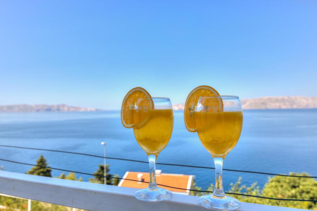 塞尼Ivan apartman的两杯葡萄酒坐在俯瞰水面的阳台