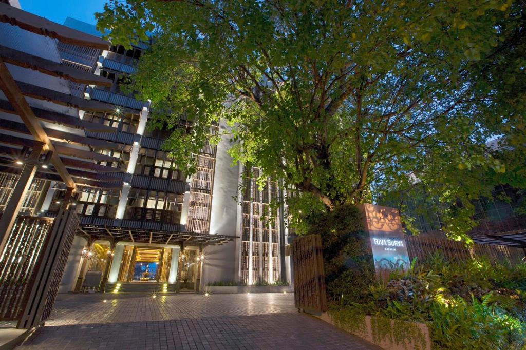 曼谷曼谷里瓦苏里亚酒店 - SHA Extra Plus的前面有棵树的建筑