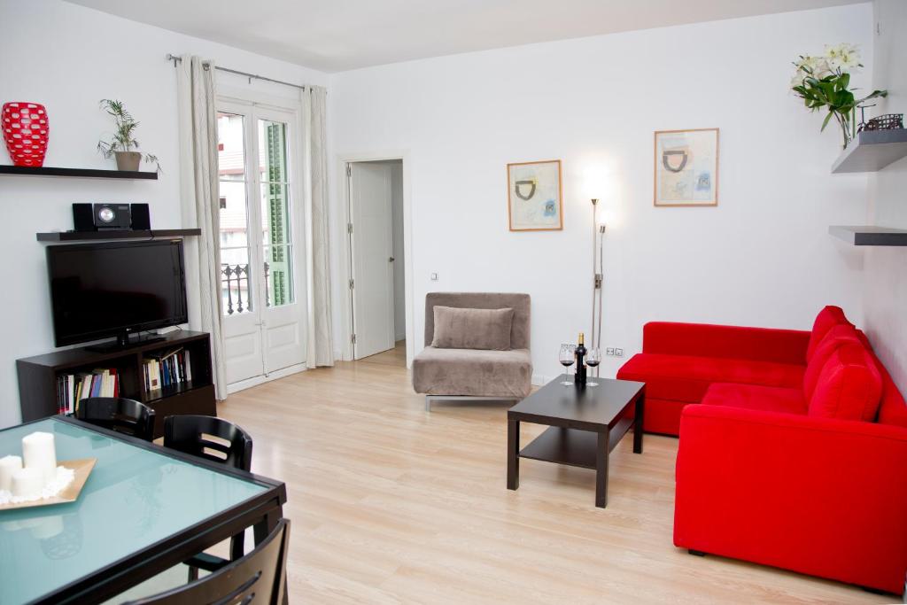 巴塞罗那克拉里斯公寓式酒店的客厅配有红色沙发和红色椅子