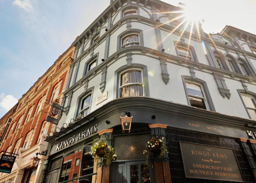 伦敦The Kings Arms Pub & Boutique Rooms的一座白色的大建筑,上面有阳光