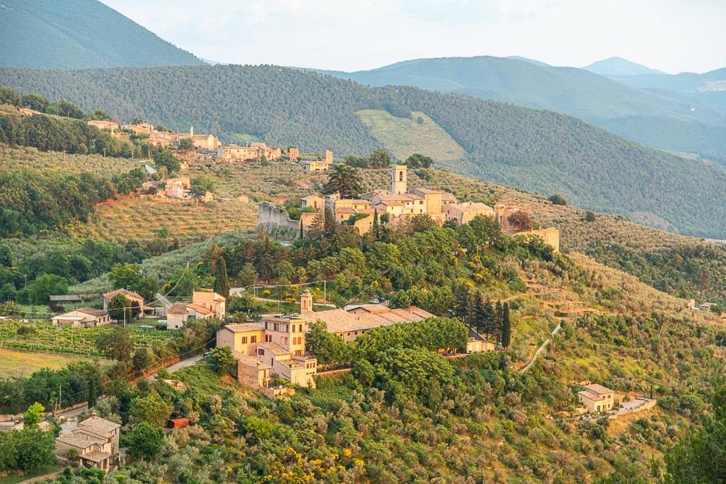 克利通诺河畔坎佩洛Relais Borgo Campello的山顶上的一个村庄,有房子