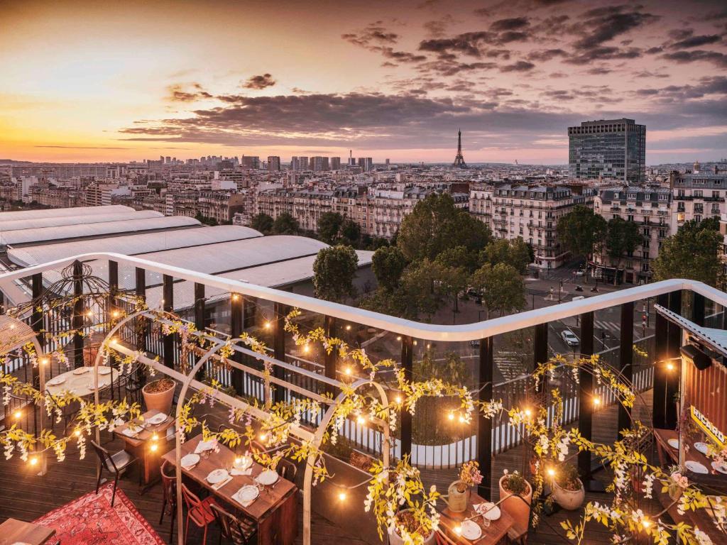 巴黎Novotel Paris Porte Versailles的设有一个灯光和市景阳台。
