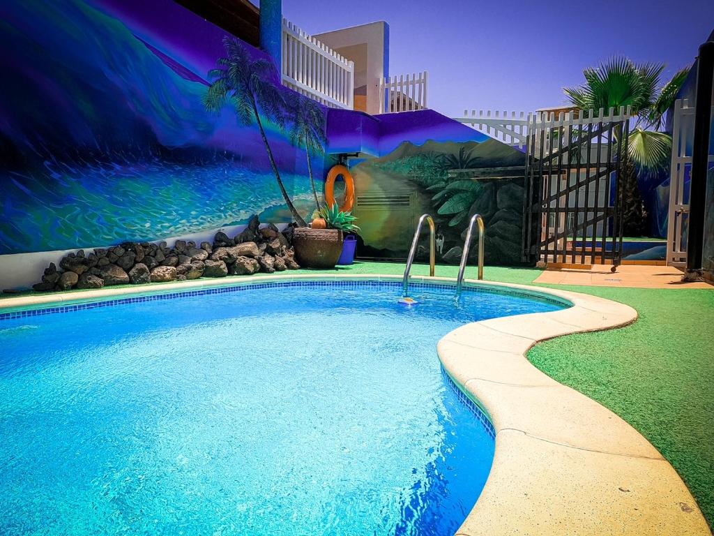 科拉雷侯富埃特文图冲浪手旅馆的后院的游泳池,带有壁画