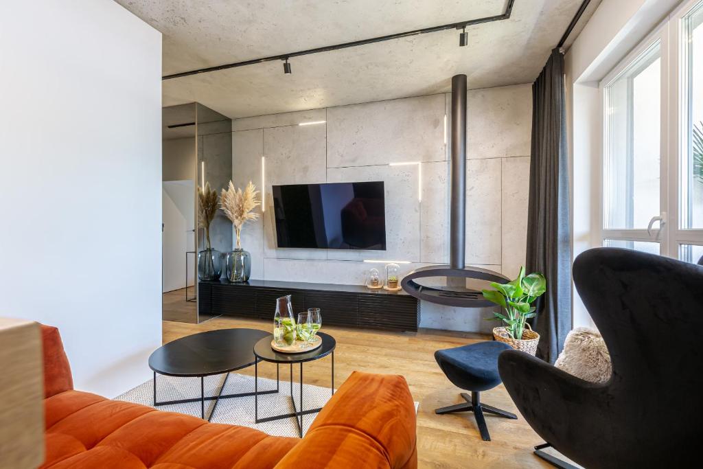 奥尔什丁Apartament Sady # 110的客厅配有橙色沙发和电视