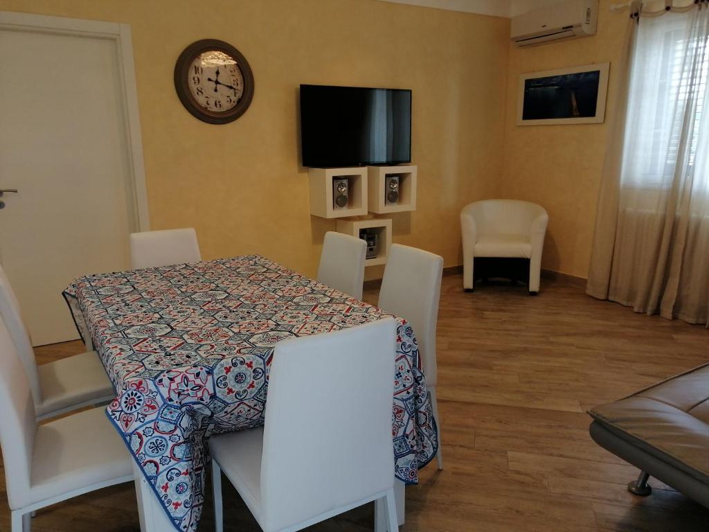 卡斯特尔韦特拉诺Villa Selinus 6598的一间带桌椅和时钟的用餐室