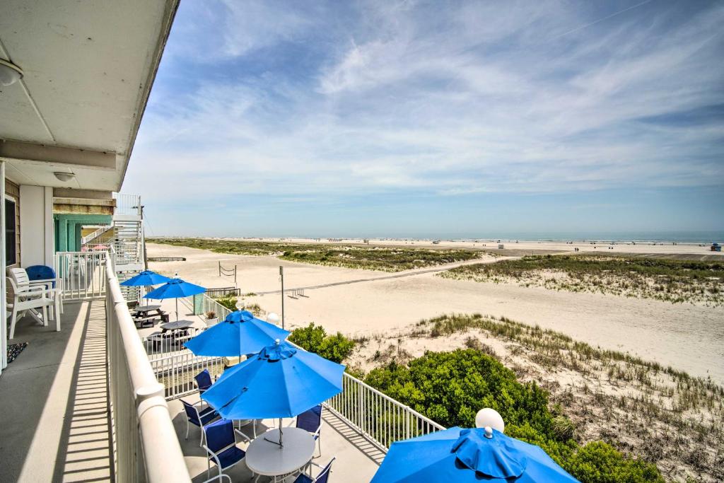 威尔伍德克拉斯特Charming Oceanfront Condo, Walk to Wildwood Beach的阳台配有蓝伞和海滩