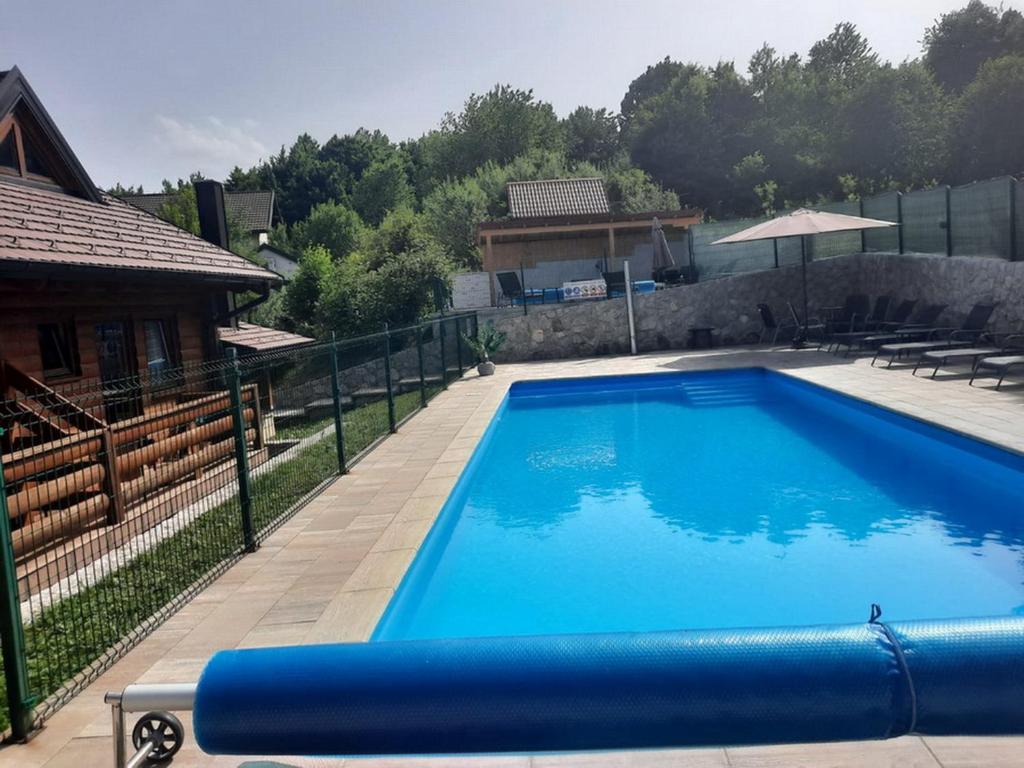 格拉博瓦茨萨拉旅馆的一座大型蓝色游泳池,位于房子旁边