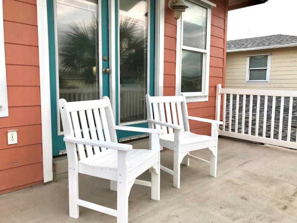 阿兰瑟斯港Coral Paradise 27VW的两把白色椅子坐在房子前门廊上