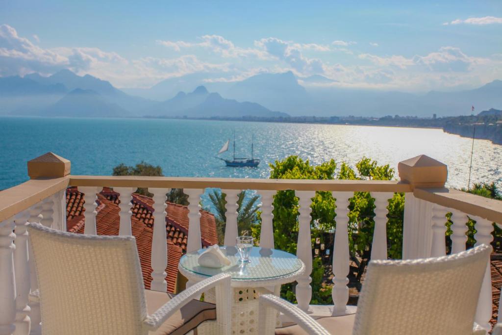 安塔利亚巴克斯彭欣酒店的俯瞰水面的阳台配有桌椅