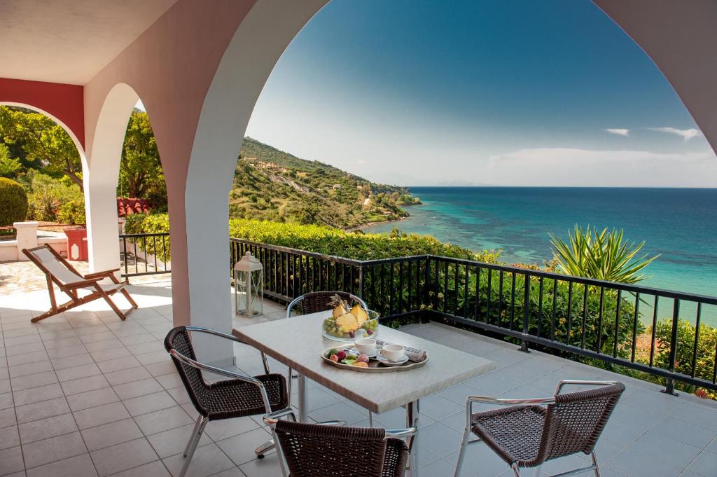 瓦西里科斯莱万特别墅酒店的一个带桌椅的海景阳台