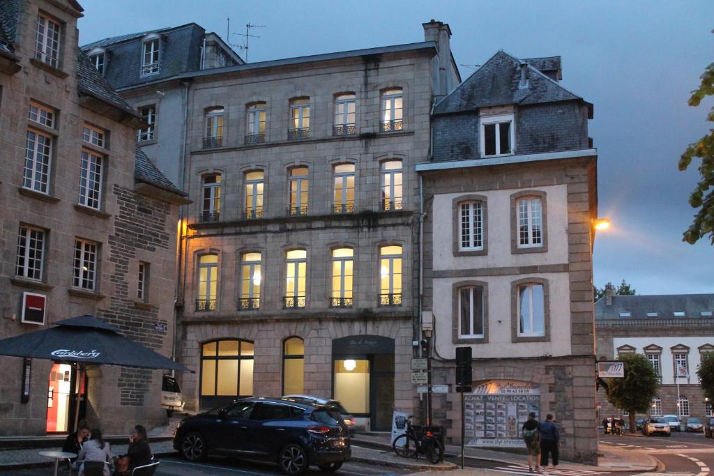 莫尔莱Duc de Bretagne Luxury Apparthotel的停在大楼前的汽车