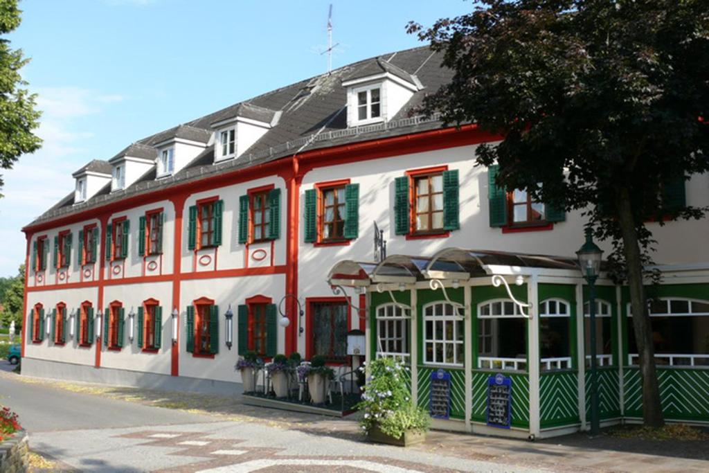 巴德瓦尔特斯多夫费舍尔餐厅酒店的白色的大建筑,红色和绿色的镶边