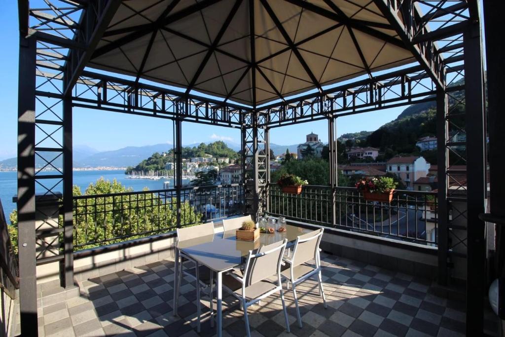 拉韦诺Maison Vittoria Lago Maggiore的阳台配有桌椅,享有水景