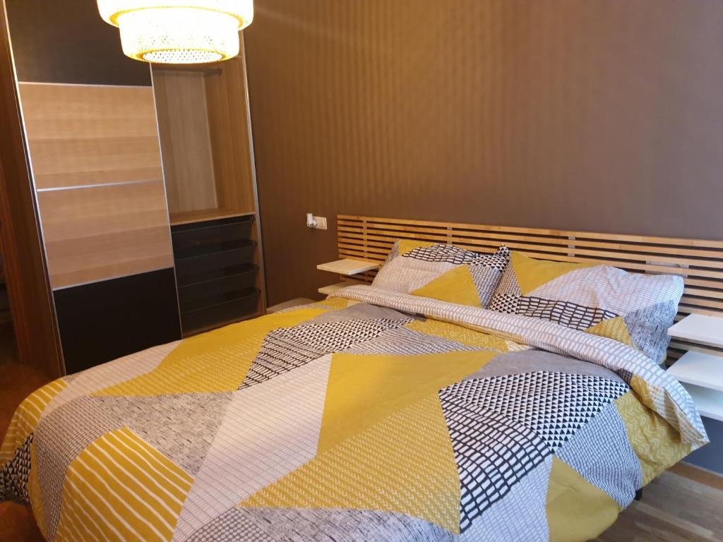 奥维多Alberto Astur Habitaciones privadas màs cocina compartida的一间卧室配有一张带五颜六色被子的床