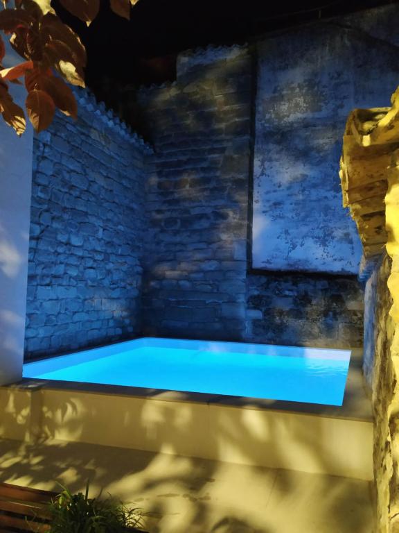 乌贝达Palacete Sol de Mayo的夜间砖墙中的热水浴缸