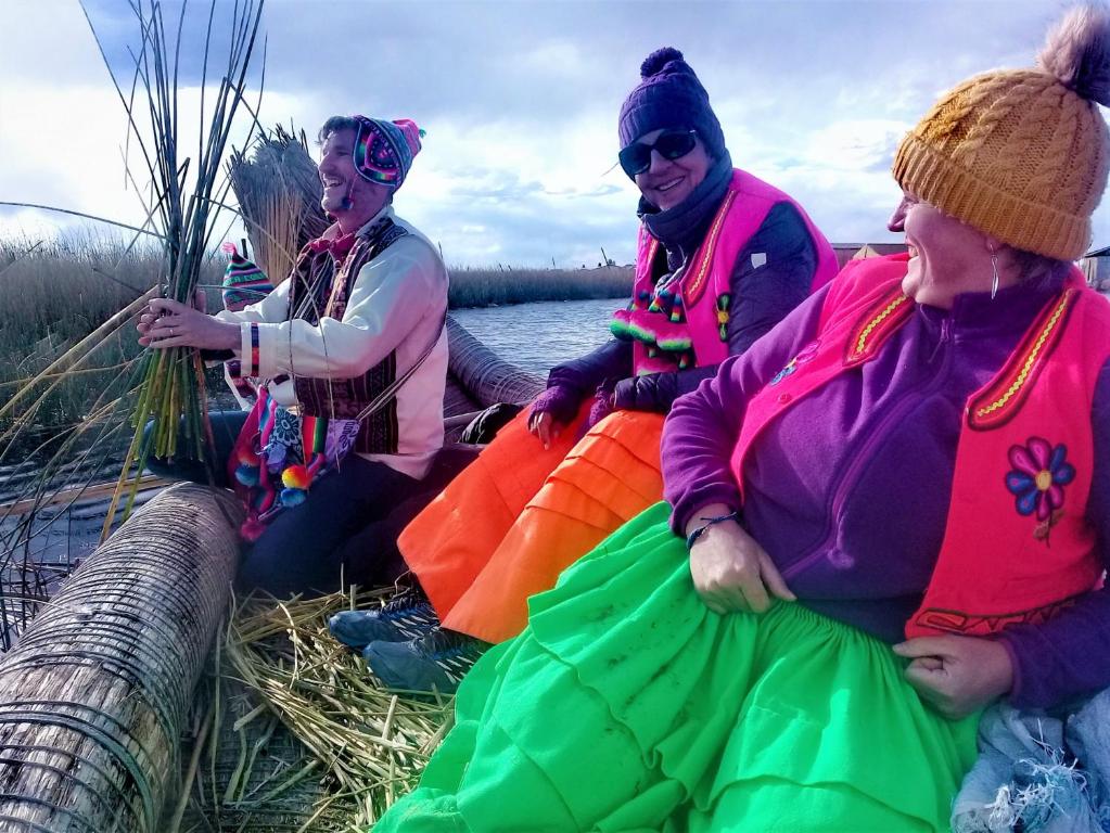 普诺Titicaca Habitación panorámica vista al amanecer的一群坐在水中的船上的妇女