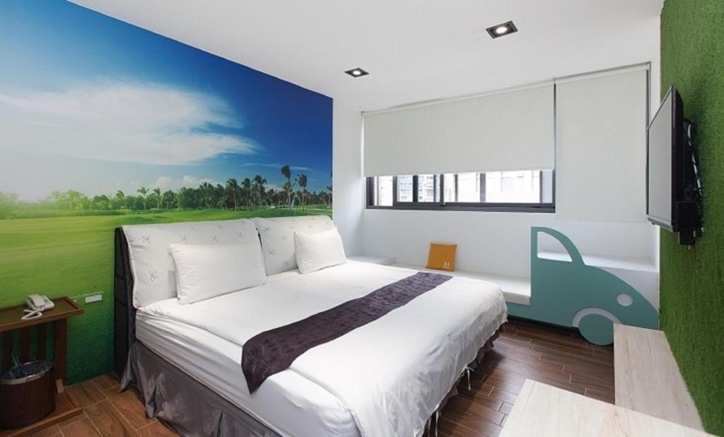 礁溪π 園周綠溫泉會館 Pi Hotspring Resort的卧室配有一张大床,墙上挂有绘画作品