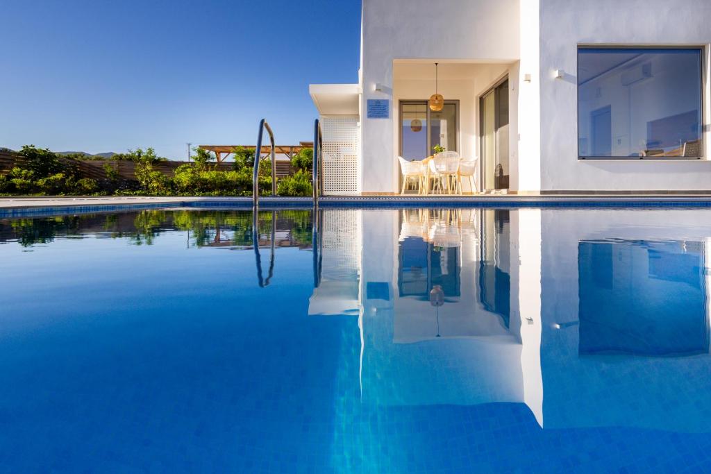 阿纳利普西Sardines Luxury Villas的一座带蓝色海水游泳池的房子