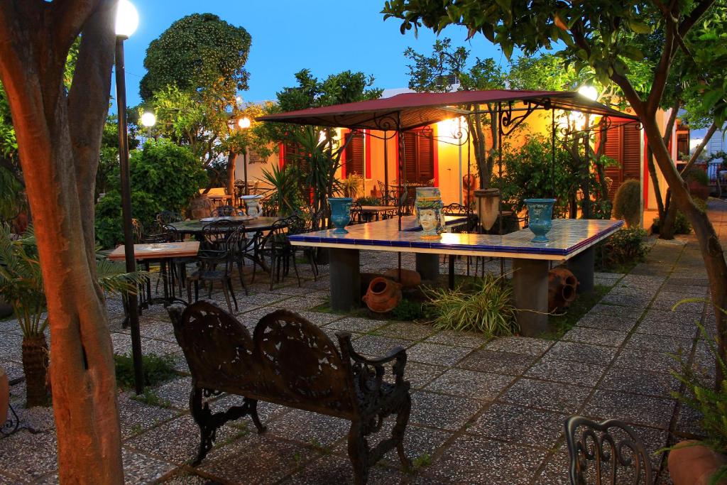 利帕里东方酒店的庭院配有桌椅和遮阳伞。