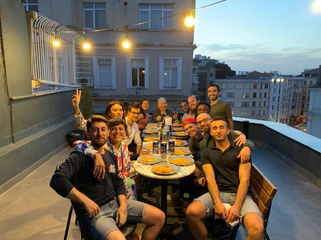 伊斯坦布尔Hostel Le Banc的一群人坐在阳台上的桌子上