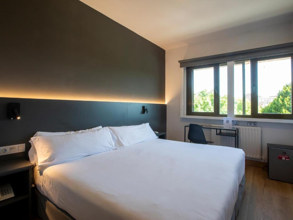 潘普洛纳桑丘拉米雷斯酒店的卧室设有一张白色大床和一扇窗户。