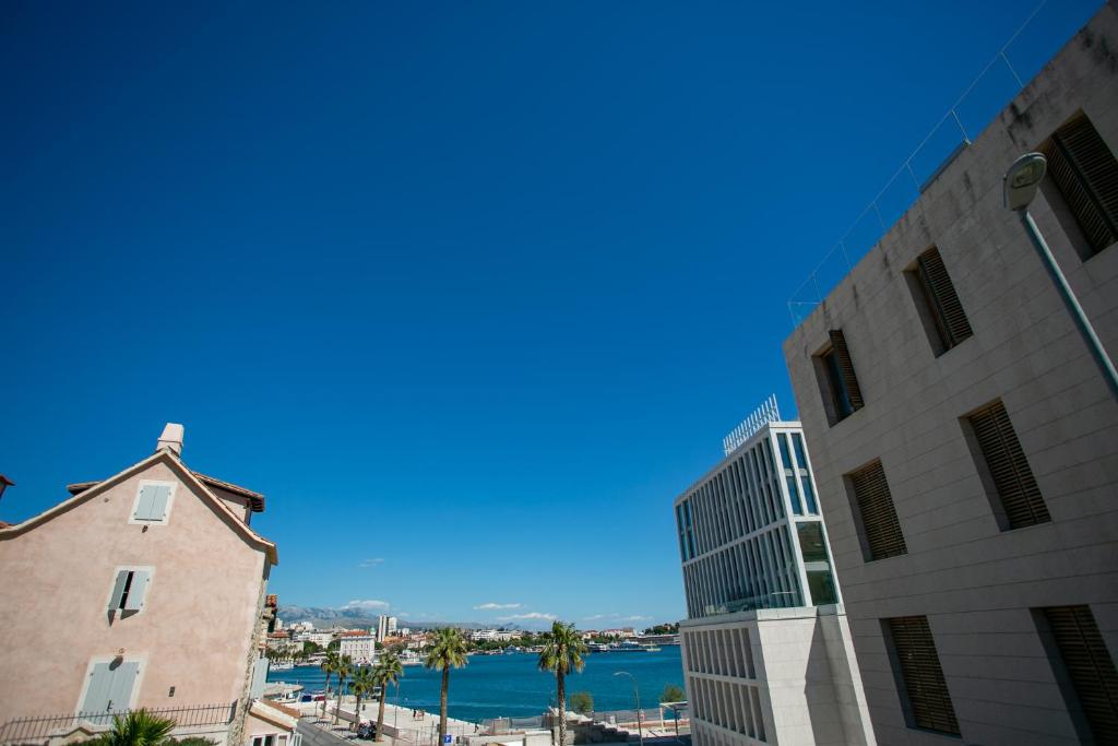 斯普利特Garden Apartment Hotel的从两栋建筑中欣赏到海景