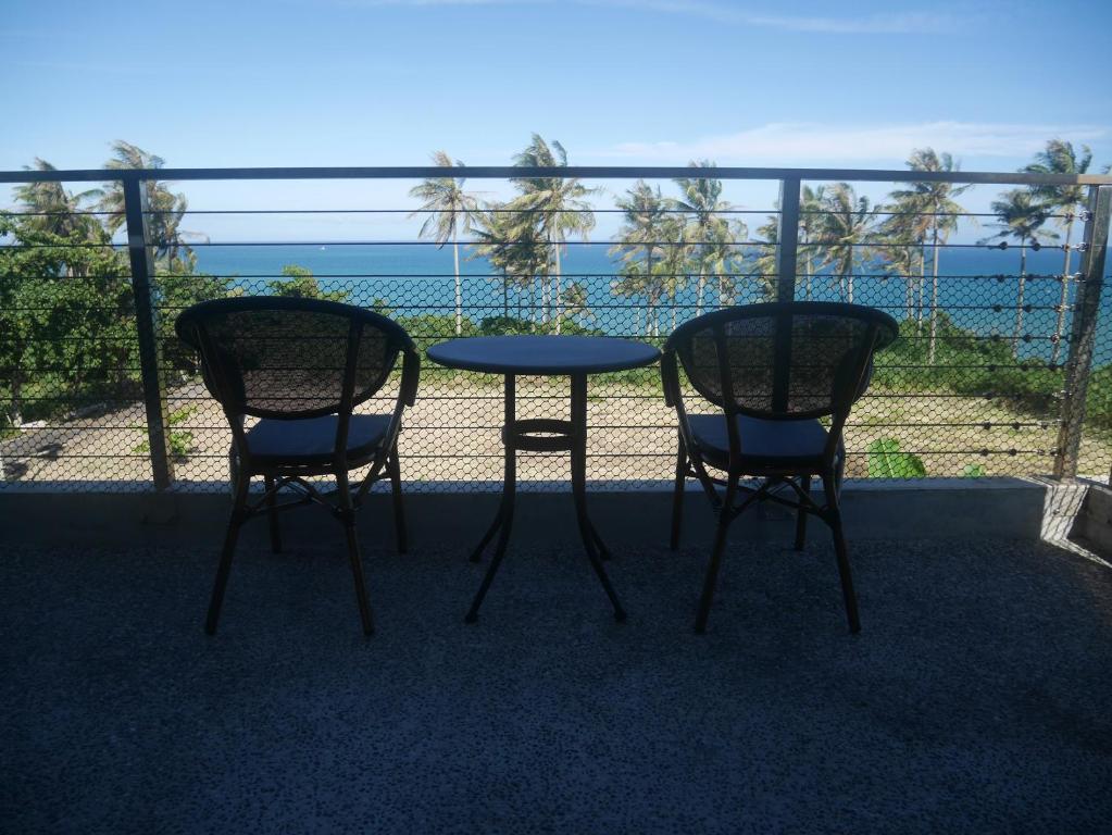 成功镇春夏秋冬海景民宿Ocean View Motel的阳台配有一张桌子和两把椅子,享有海景