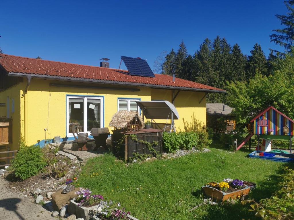 上罗伊特Ferienwohnung im Landhausstil的黄色的房子,前面有一个花园