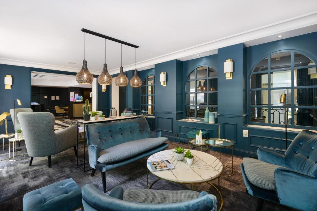 巴黎皇家左岸酒店的一间拥有蓝色墙壁、椅子和桌子的房间