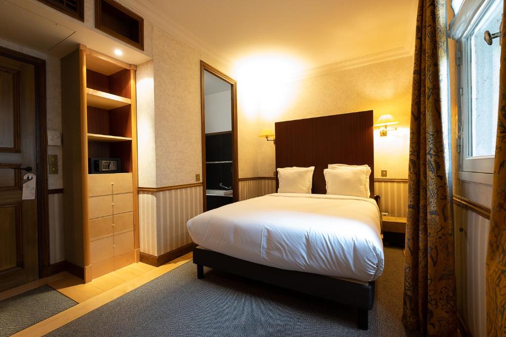 巴黎Hôtel Relais Monceau的酒店客房设有床和窗户。