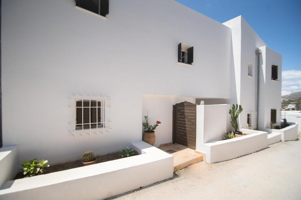 金尼昂Lotos Beach Home的白色的房子,拥有白色的墙壁和植物