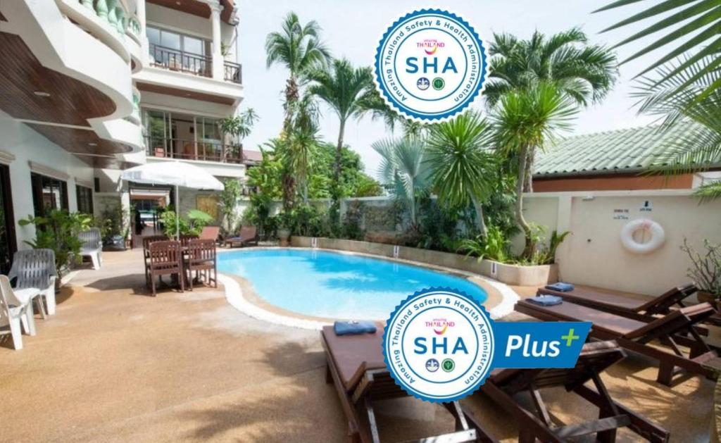 芭东海滩棕榈景度假酒店的一个带桌椅的度假村游泳池