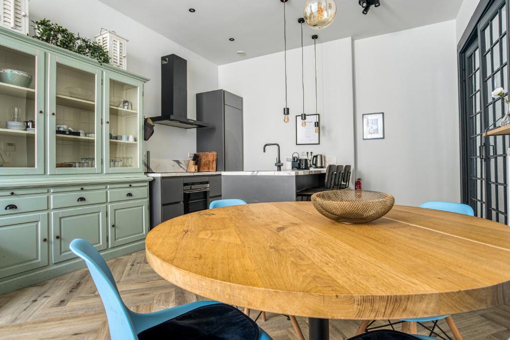 斯海弗宁恩Hosted by Wendy Prins Willem 1的厨房配有木桌和蓝色椅子