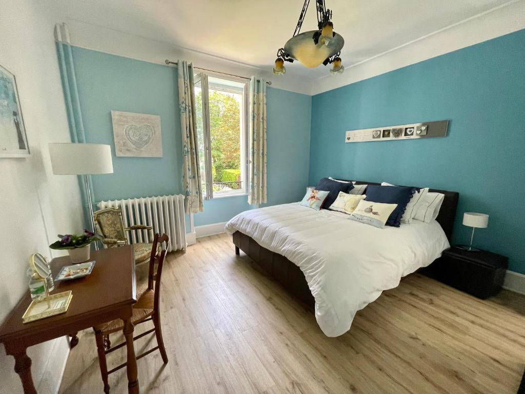 唐莱沃斯热La Maison Bleue « La Charade »的一间卧室设有蓝色的墙壁、一张床和一张书桌
