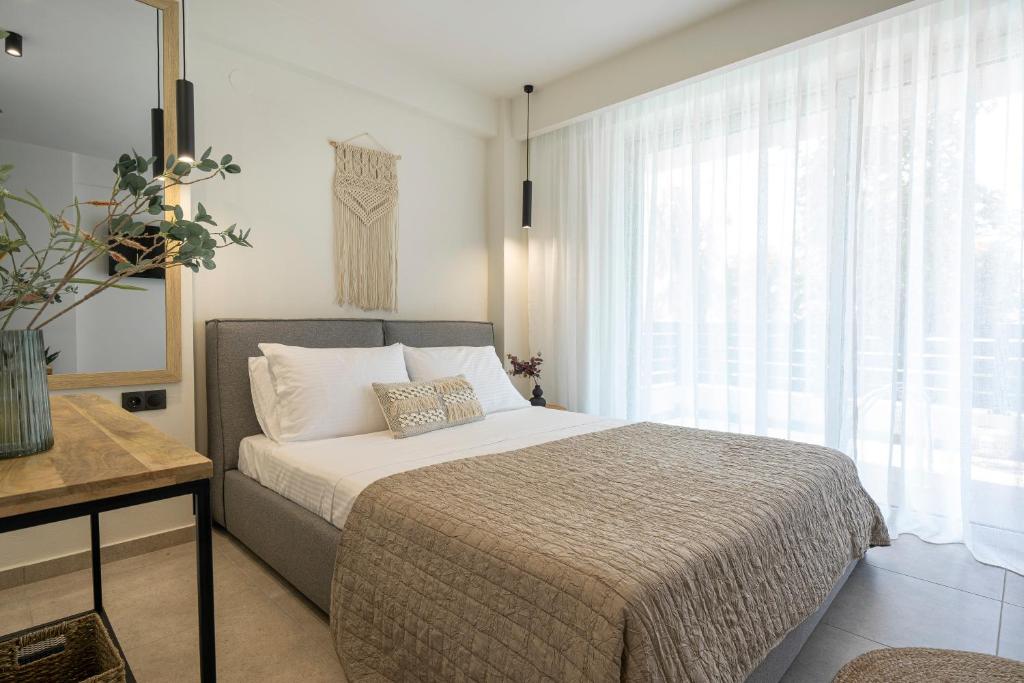 内亚卡瓦里Aelia Seaside Luxury Suites的一间卧室设有一张床和一个大窗户