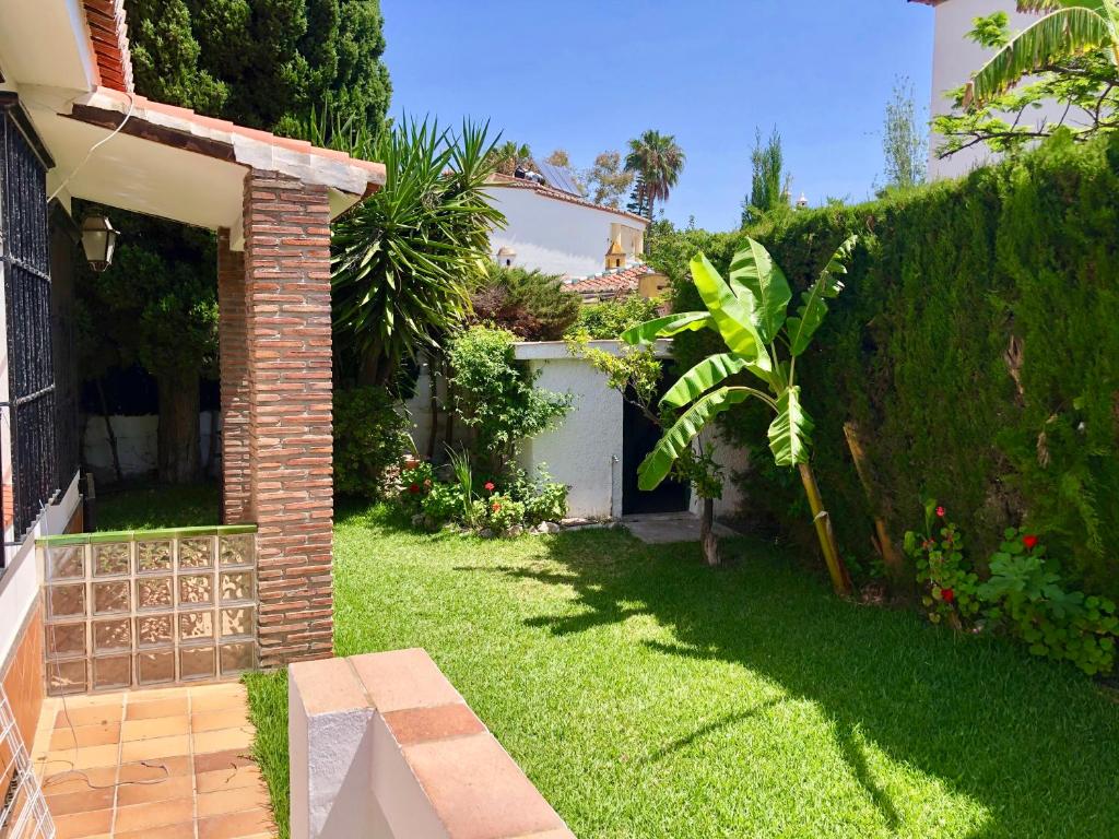 阿尔姆尼卡Precioso Chalet en Almuñecar junto al Mar con Garage privado的一个带砖墙和花园的院子