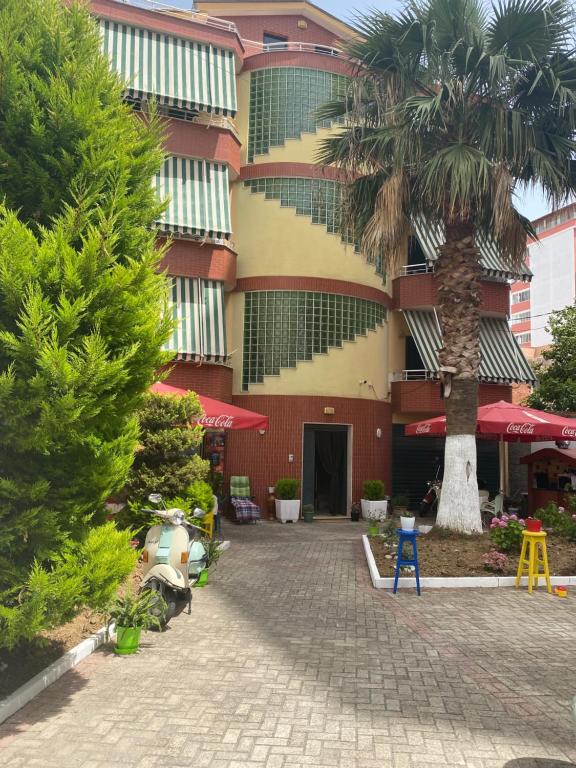 都拉斯Hotel Durres Vila 53的前面有棕榈树的建筑